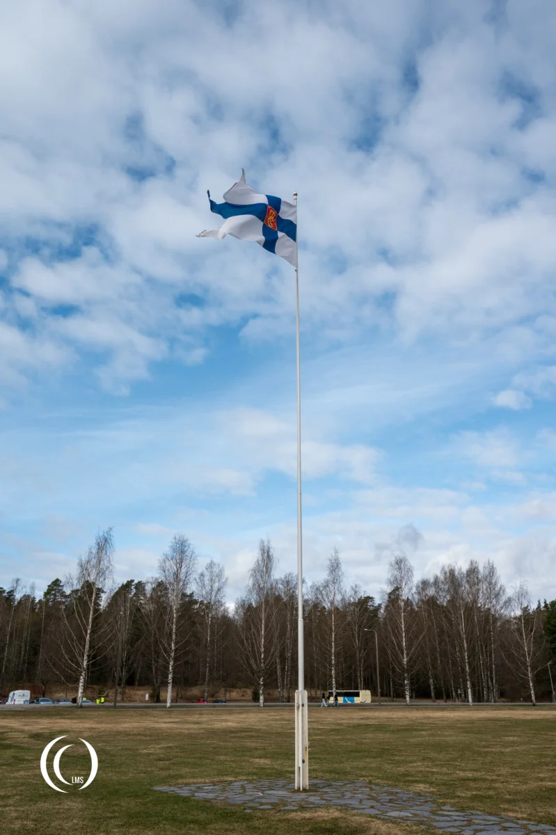 The Flag of Finland (siniristilippu) opposite the Armored Monument in Hattula, Finland